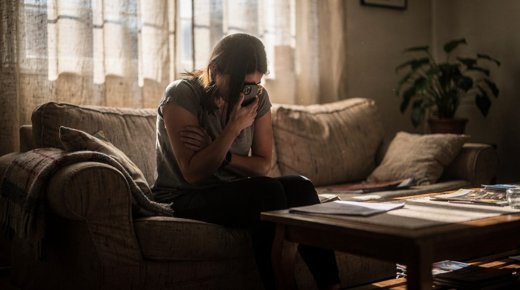 Femme anxieuse regardant son téléphone avec des notifications en rafale