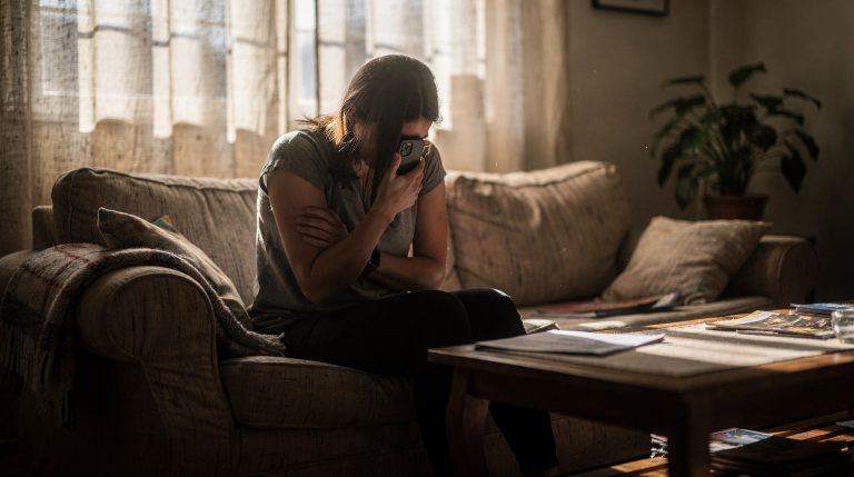 Femme anxieuse regardant son téléphone avec des notifications en rafale