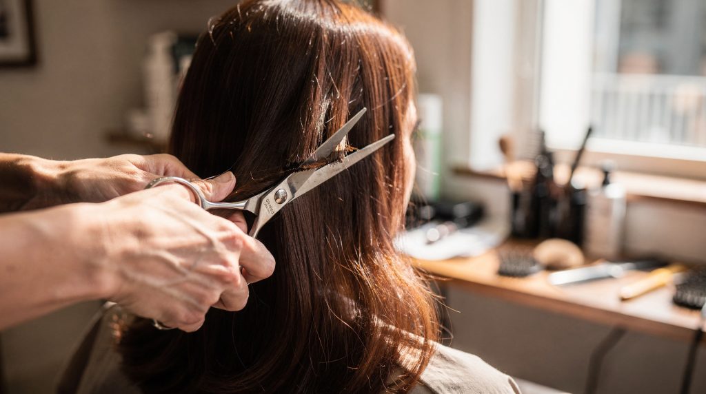 Coiffeuse réalisant un carré plongeant sur une cliente en salon