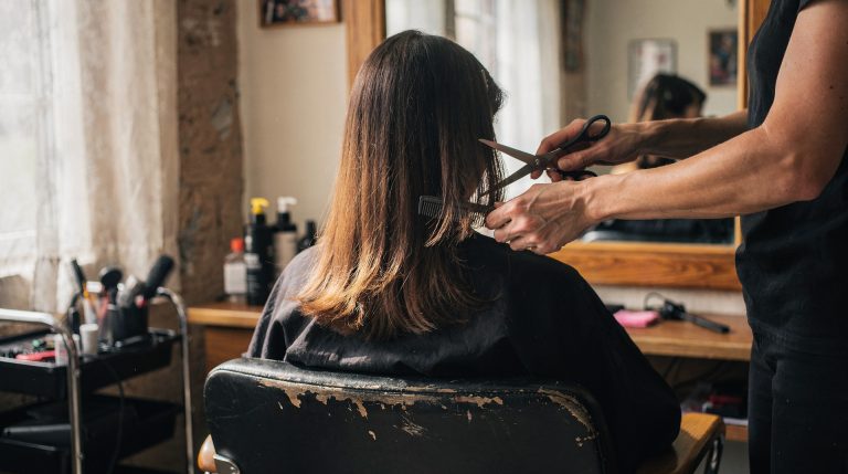 Femme se faisant coiffer en salon