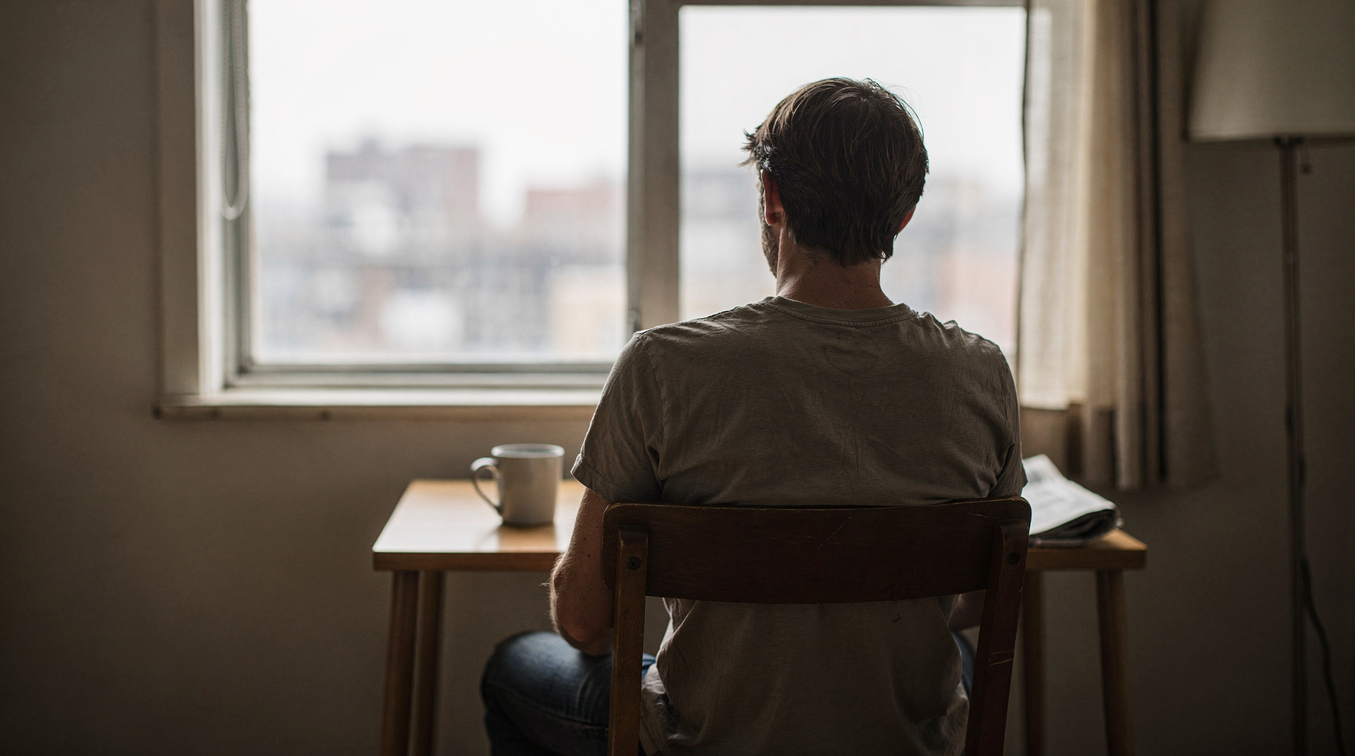 Homme pensif près d'une fenêtre