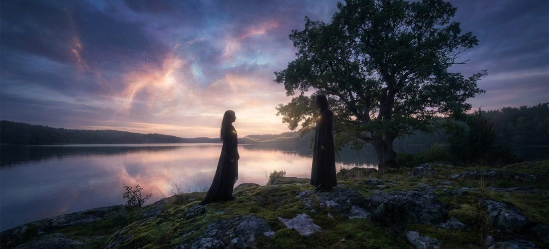Deux silhouettes sur une rive rocheuse, reliées par un lien doré lumineux, face à face devant un lac miroitant un ciel crépusculaire.