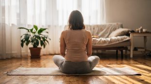Femme enceinte en posture de yoga prénatal sur un tapis