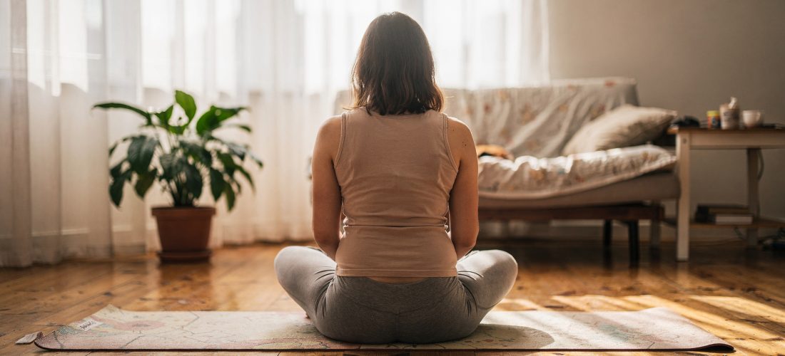 Femme enceinte en posture de yoga prénatal sur un tapis