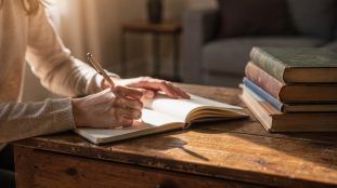 Mère écrivant des prénoms dans un carnet ouvert